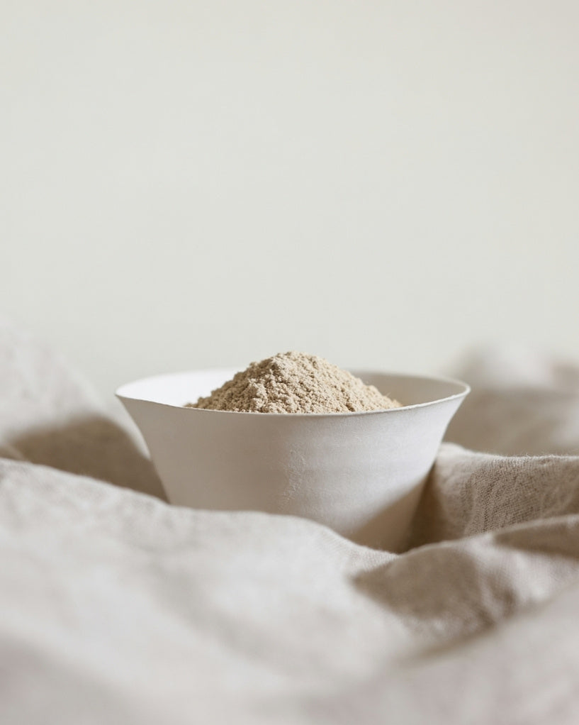 White bowl with sitopiladi powder on a textured surface